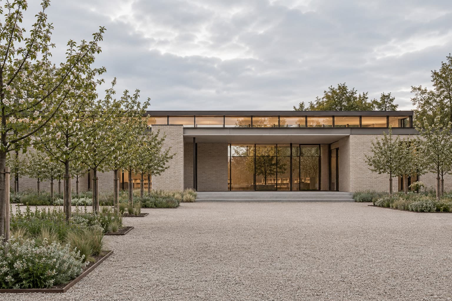 A low pale-brick library pavilion set among young fruit trees under soft overcast light